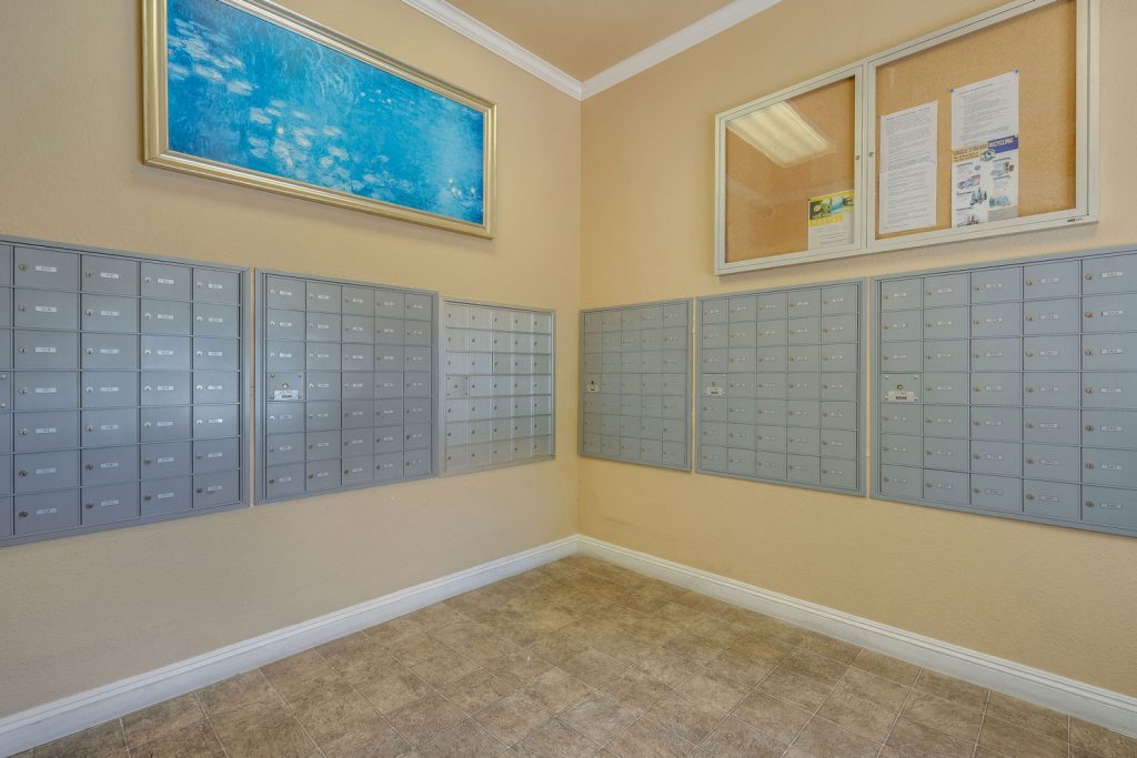 Mail room with mailboxes built into the wall and a community bulletin board.